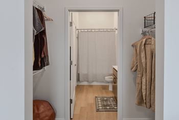 A white door with a curtain and a rug on the floor.